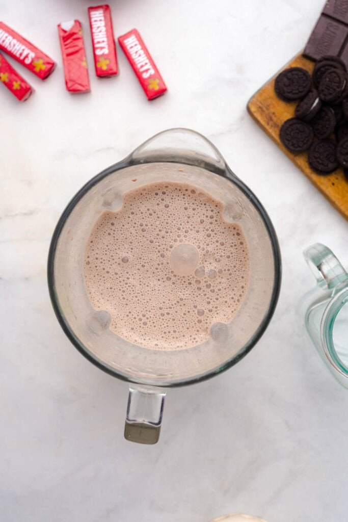 Top view of a blender with chocolate milkshake, surrounded by Hershey's bars and chocolate sandwich cookies&mdash;perfect for your next Chocolate Freakshake or creative Chocolate Recipe.