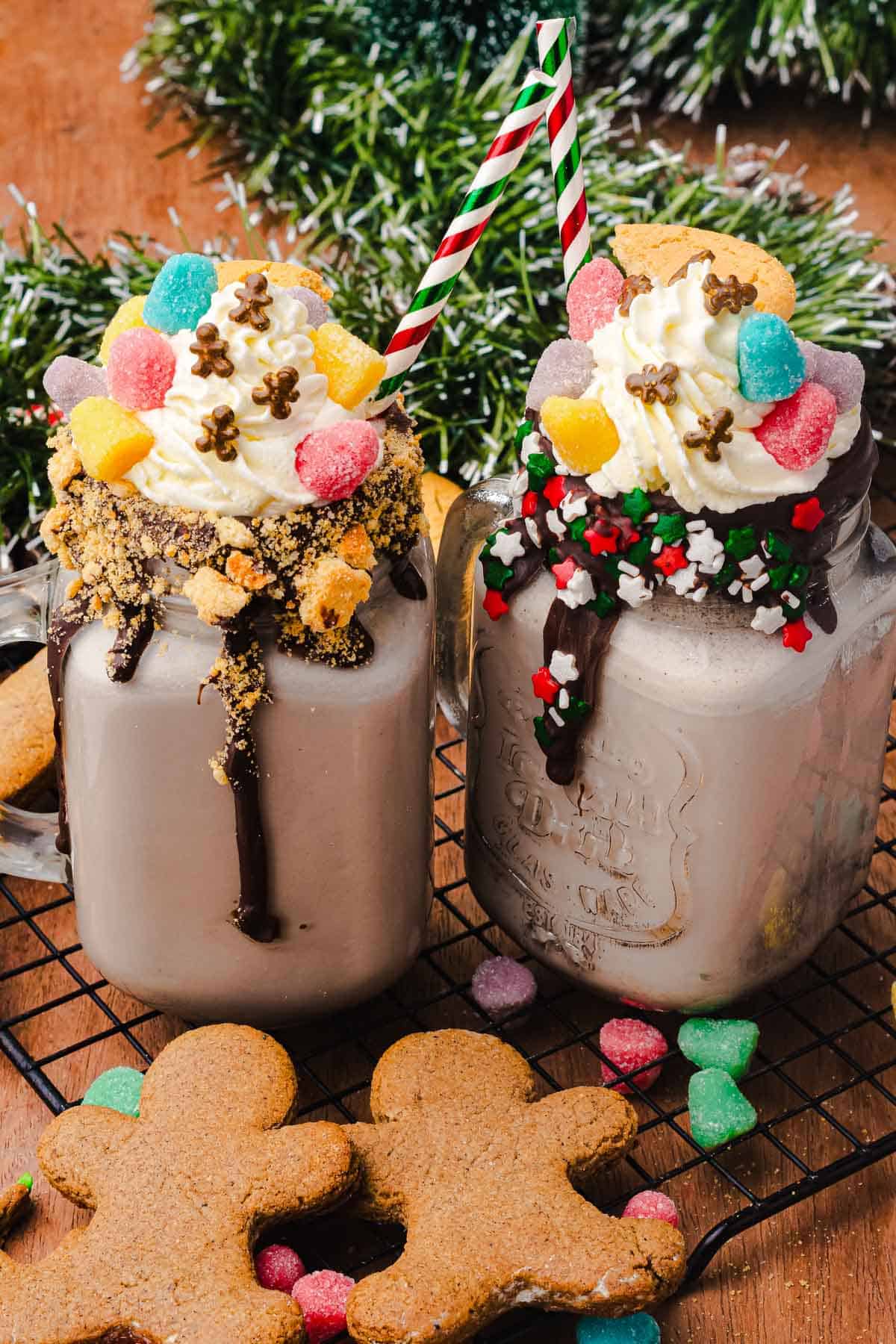 Two festive Gingerbread Freakshakes topped with whipped cream, candies, cookies, and sprinkles are the perfect Christmas treat&mdash;with gingerbread cookies nearby for extra holiday cheer. Try this fun freakshake recipe for your next celebration!.