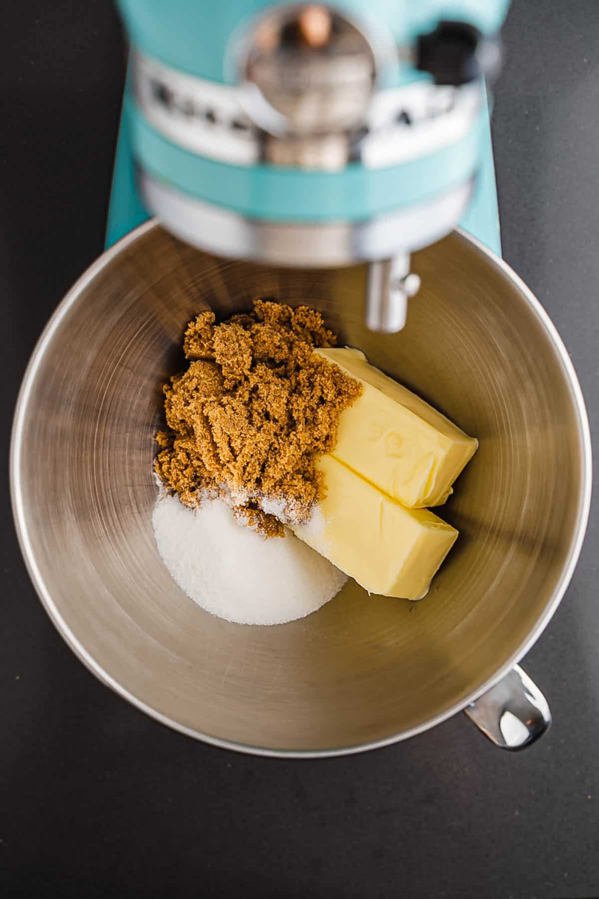 Mixing bowl with brown sugar, white sugar, and two sticks of butter under a stand mixer&mdash;perfect for starting your S'mores Cookies recipe.