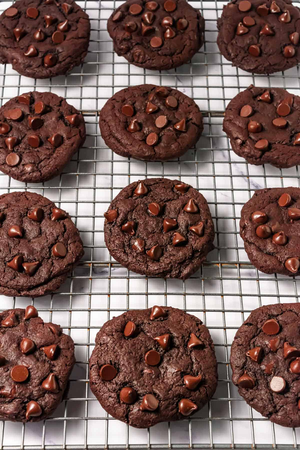 Dark Dream Cookies with rich chocolate chips cooling on a wire rack&mdash;your ideal Crumbl Copycat treat.