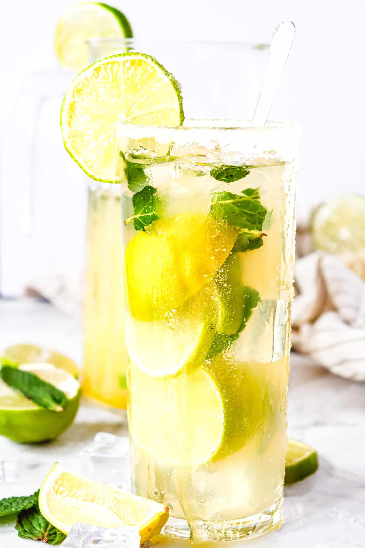 A tall glass of Virgin Mojito with lime slices, mint leaves, ice, and a lime wedge garnish on the rim&mdash;an irresistible mocktail recipe for refreshing moments.