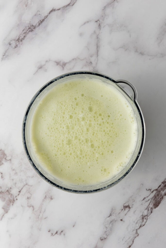A bowl of frothy, pale green liquid&mdash;reminiscent of Brazilian Limeade&mdash;sits on a white marble surface.