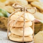 Stack of four Amish lemon cookies tied with twine, with more cookies blurred in the background.