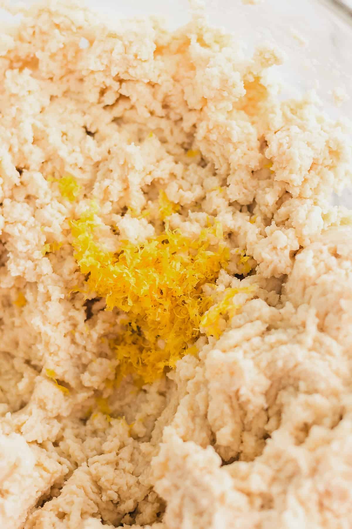 A bowl of cookie dough mixture topped with fresh lemon zest, ready to become delightful Lemon Sugar Cookies inspired by classic Amish recipes.