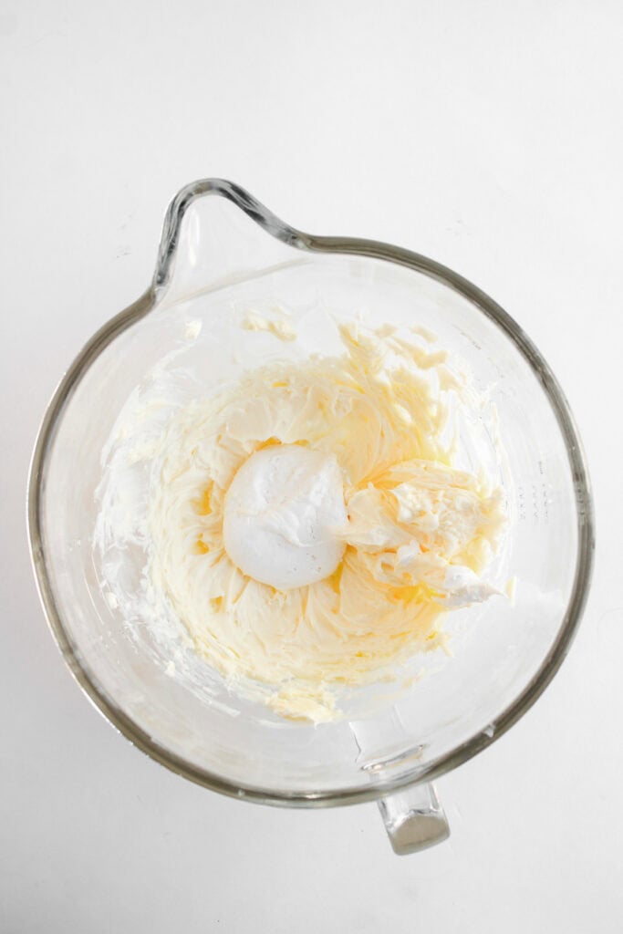 Glass bowl with whipped butter and a dollop of what appears to be cream or egg whites on top&mdash;perfect for frosting cupcakes or adding a Dole Whip twist to your baking creations.