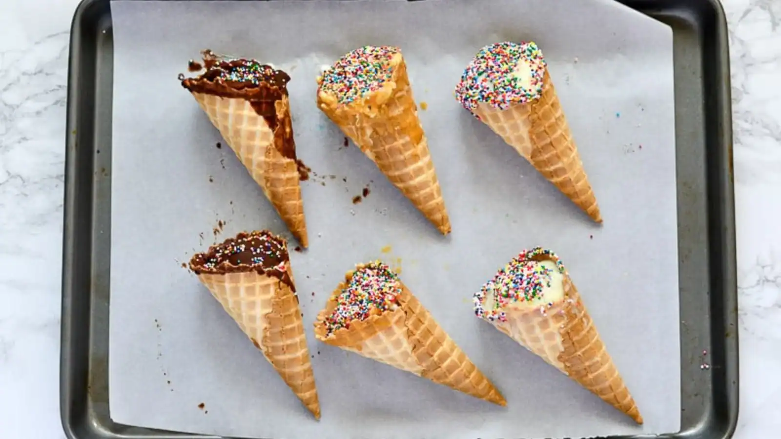 Overhead shot of 6 cones, two in chocolate, two peanut butter, two vanilla.