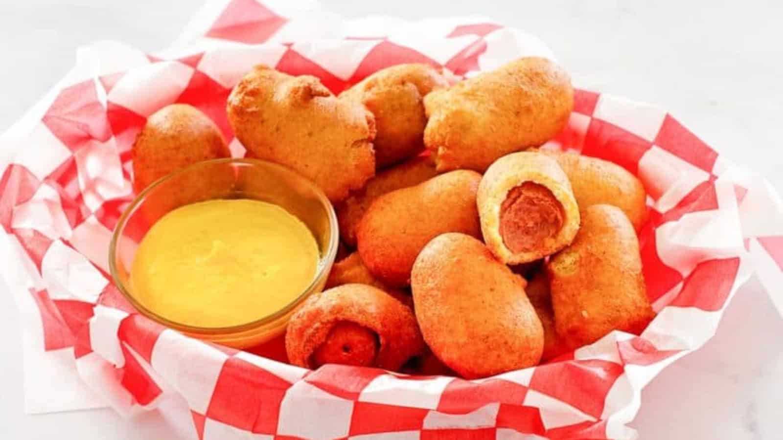 Mini corn dogs with a crispy golden batter served with dipping sauce.