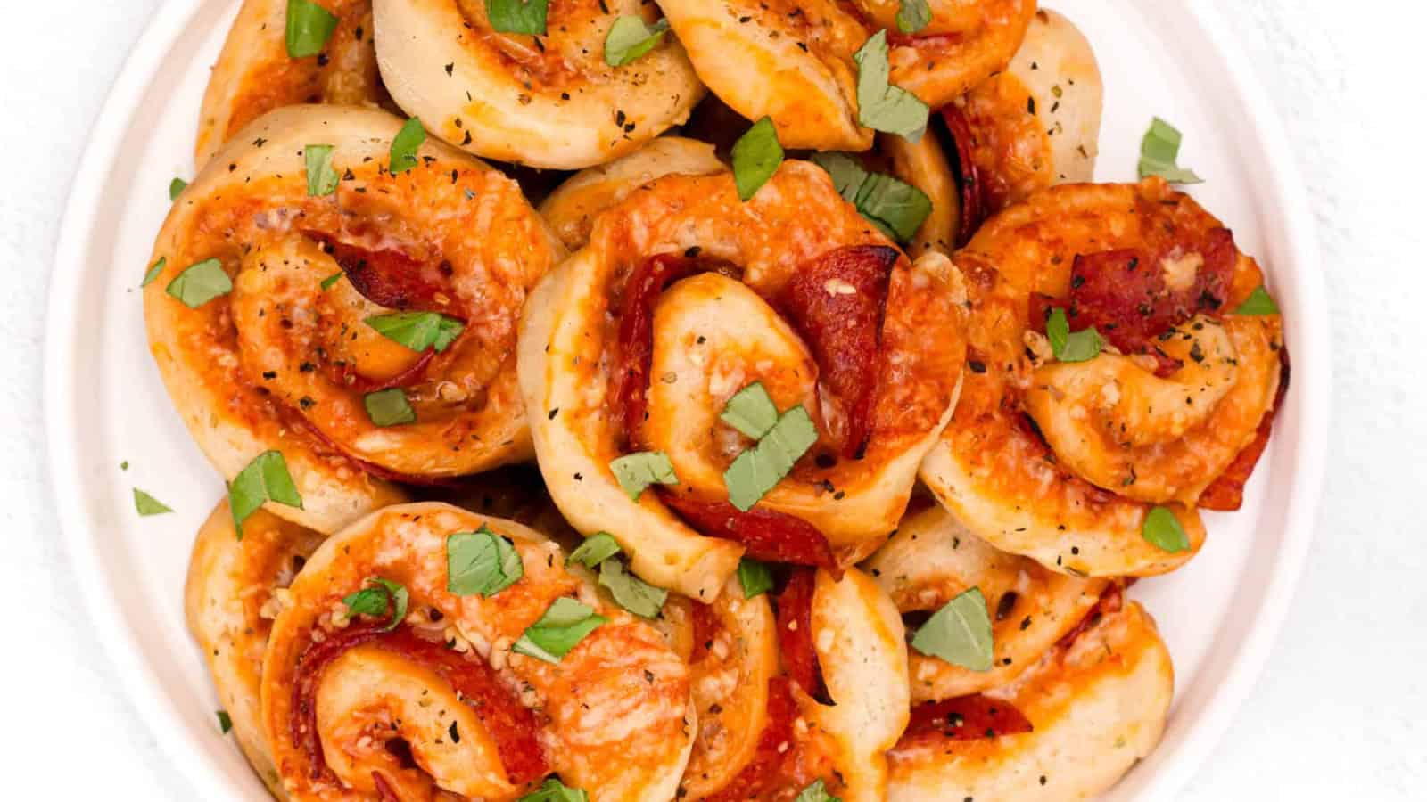 Pizza pinwheels filled with cheese and pepperoni and served with marinara sauce.