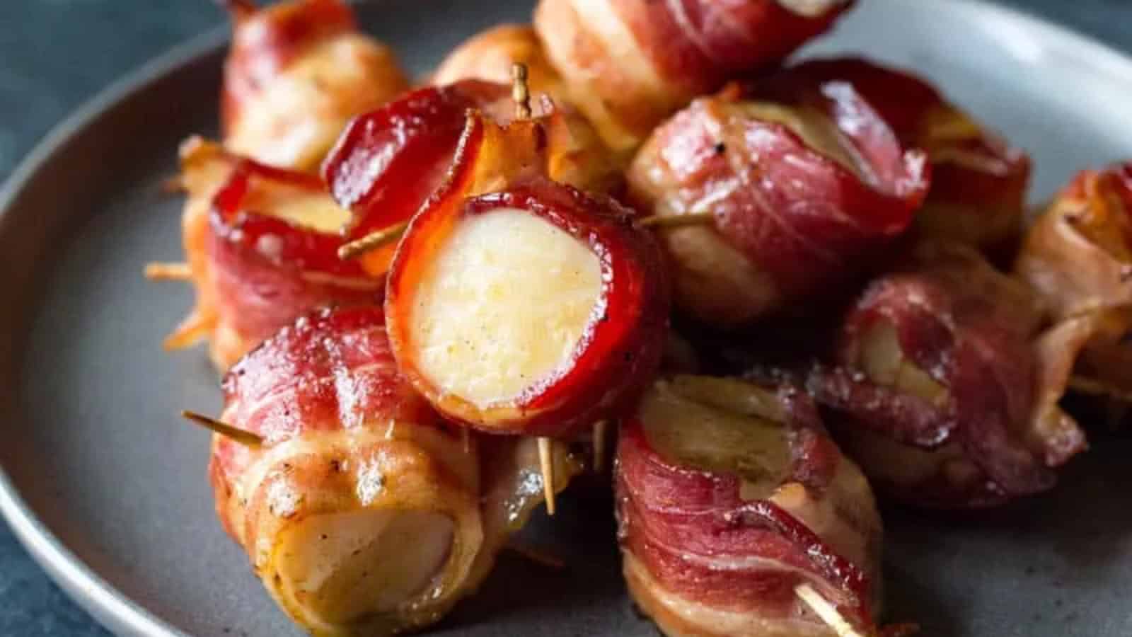 Bacon-wrapped scallops cooked until golden and served with fresh herbs.
