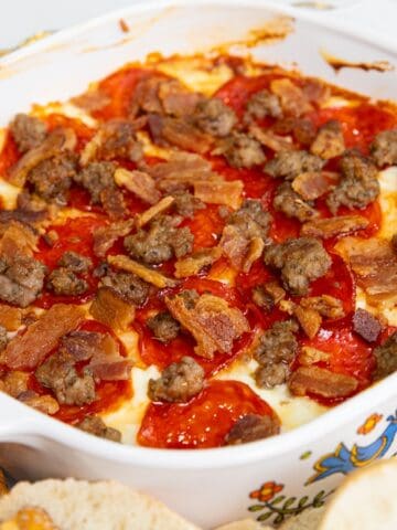 Baked ziti with ground beef, red sauce, and melted cheese in a white baking dish.