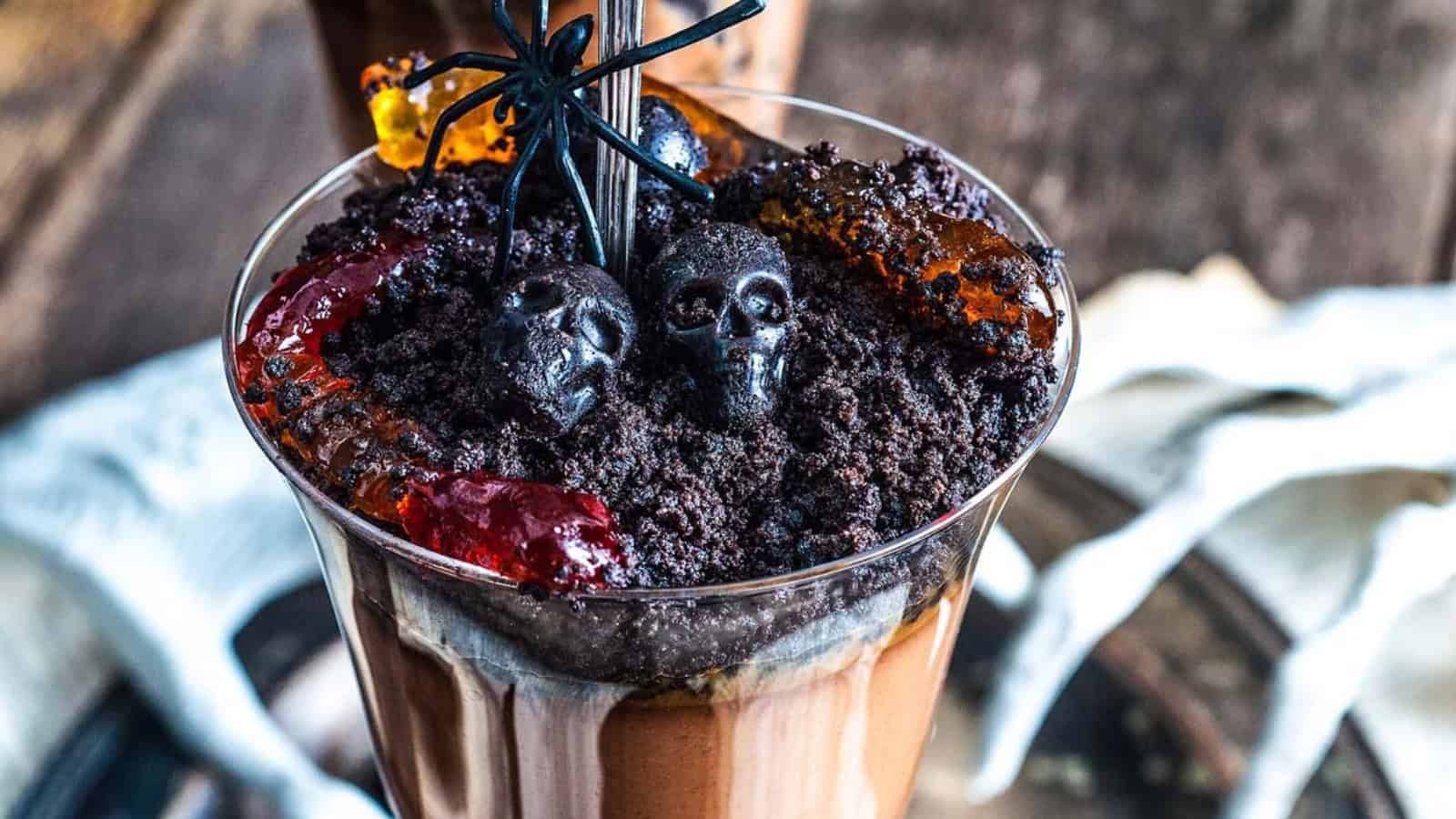 Halloween dirt dessert topped with cookie crumbs and decorative words.