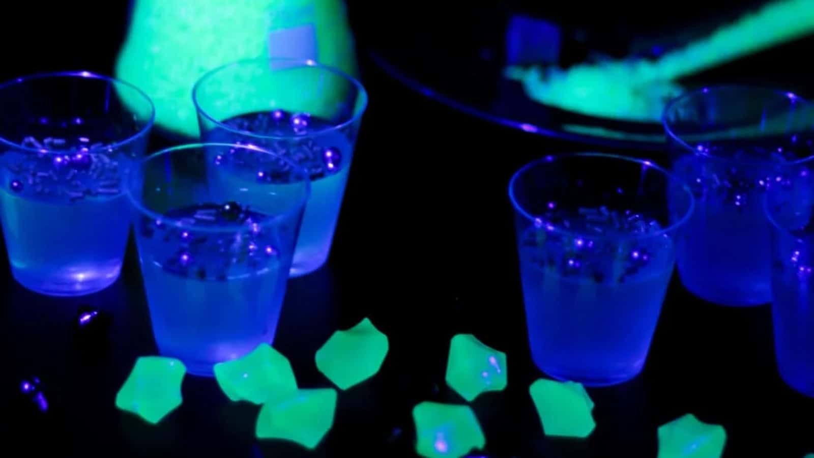Glow-in-the-dark Jell-O shots in small cups.