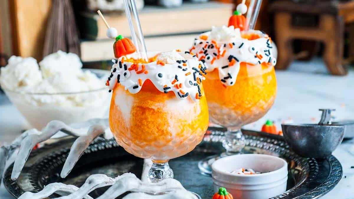 Halloween spooky floats topped with whipped cream and festive Halloween decorations.