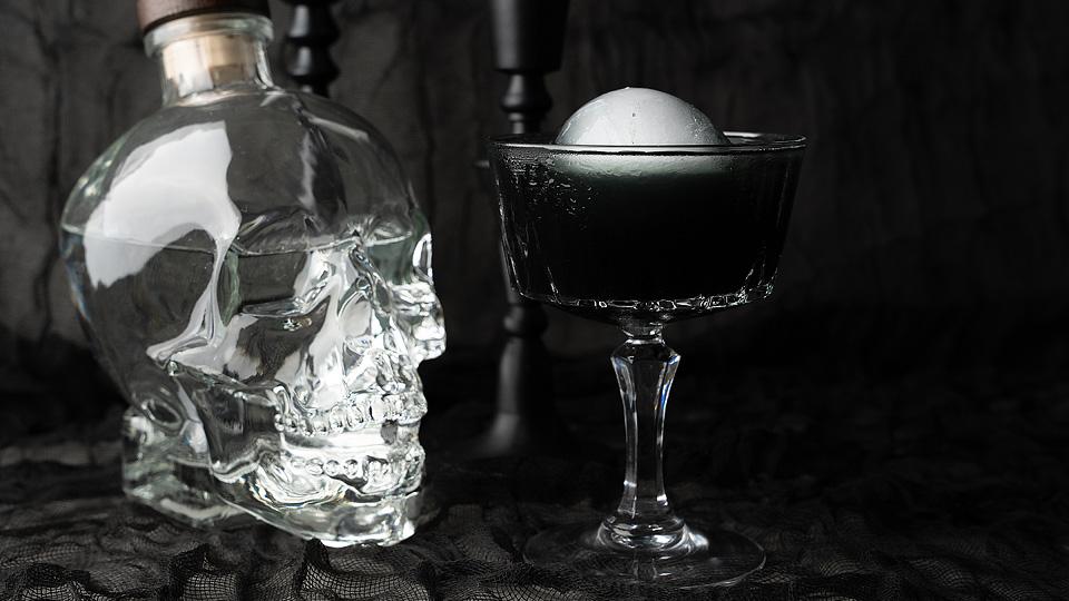 Black Halloween Cosmopolitan cocktail with a dark color and spooky garnish.